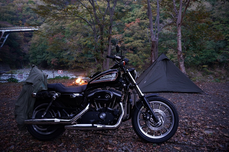 バイクと焚火とテントの写真